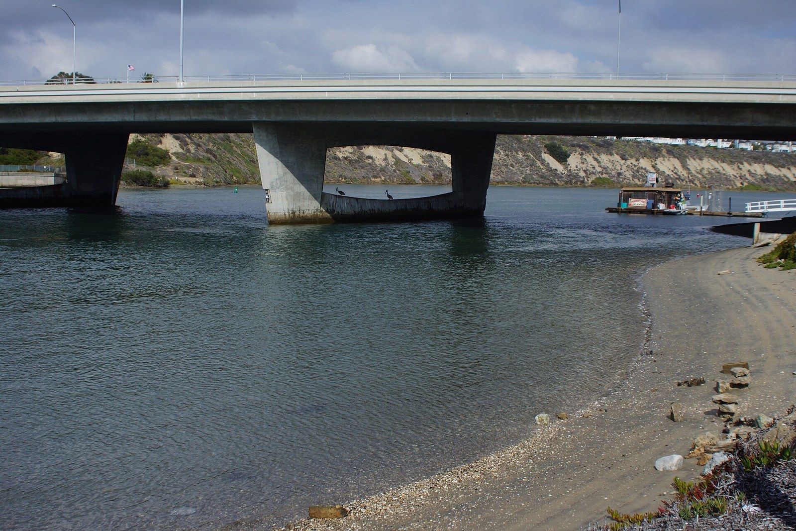The Coast Highway bridge over the bay at Bayside Drive, with a sandy shore